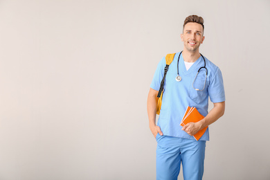 Male medical student on light background